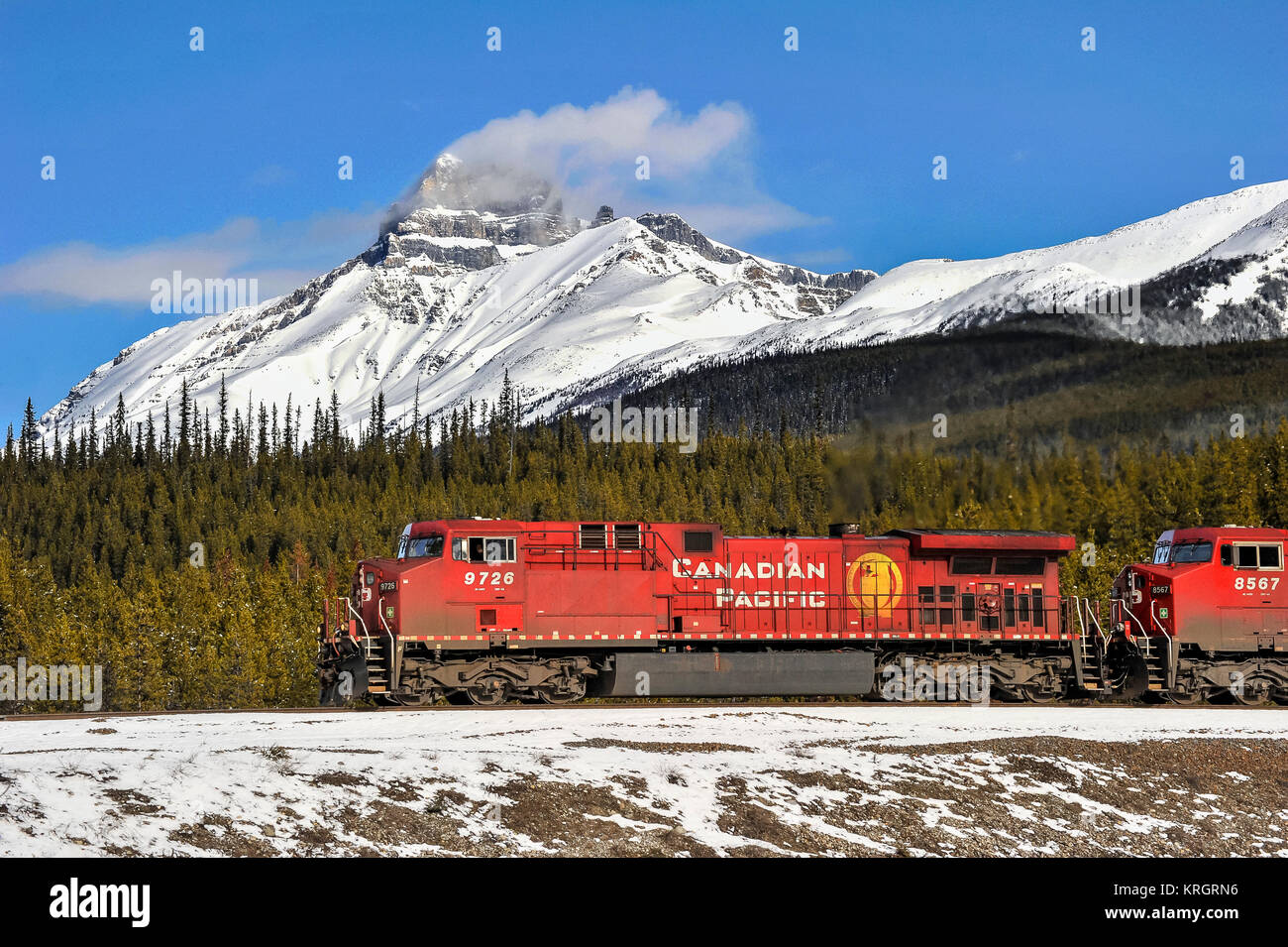 CP Rail grain train led westbound by loco 9726 passes below Mt Hector in winter in Banff Park Alberta Stock Photo