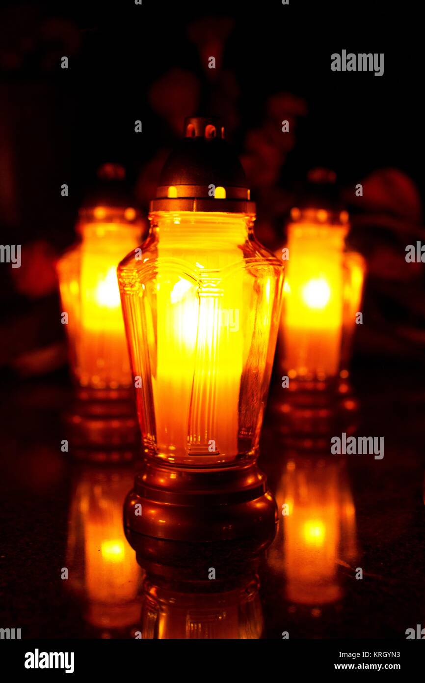 glowing candles on the grave 3 Stock Photo - Alamy