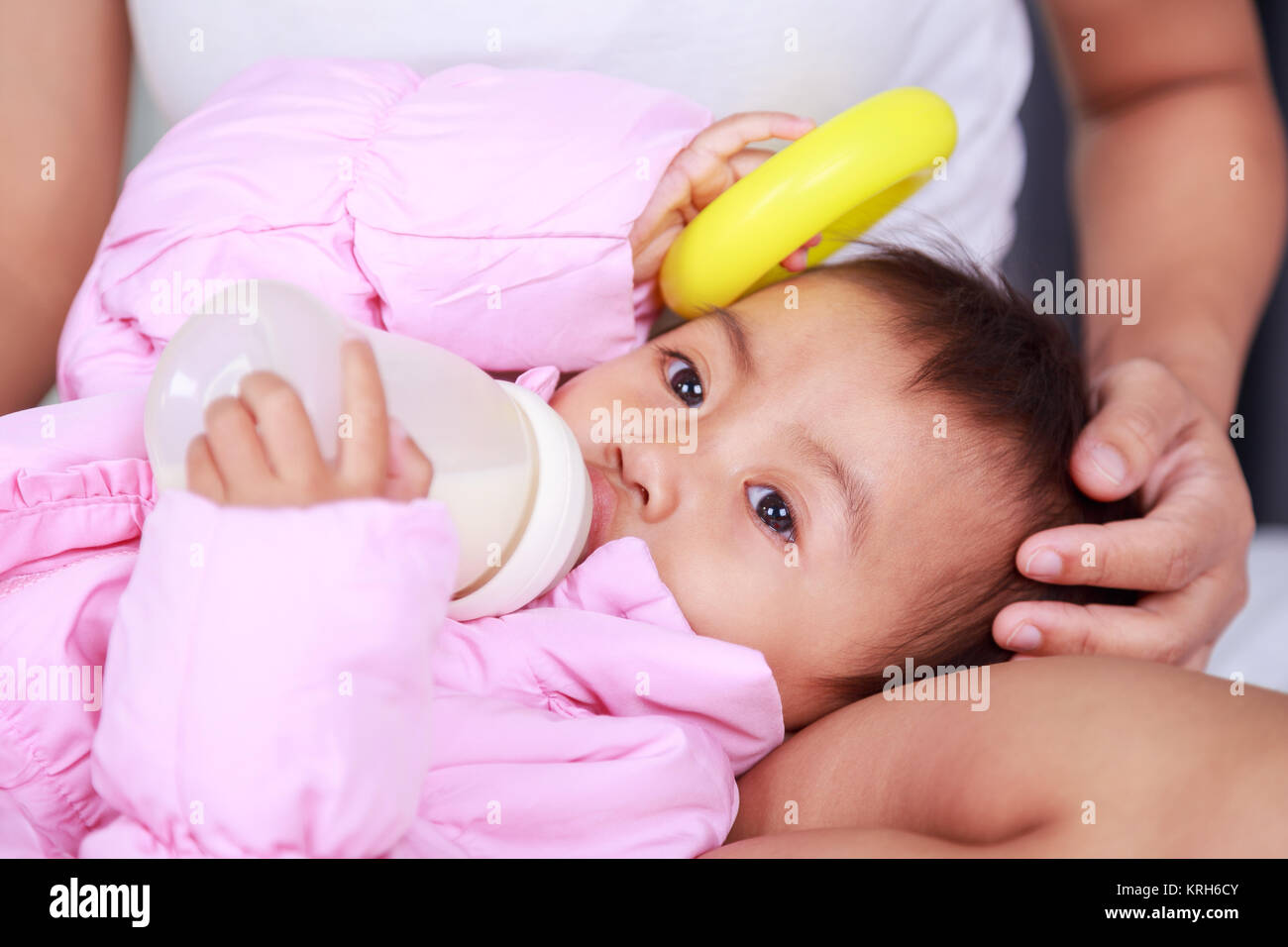 baby drinking a milk from bottle with mother on a bed Stock Photo Alamy