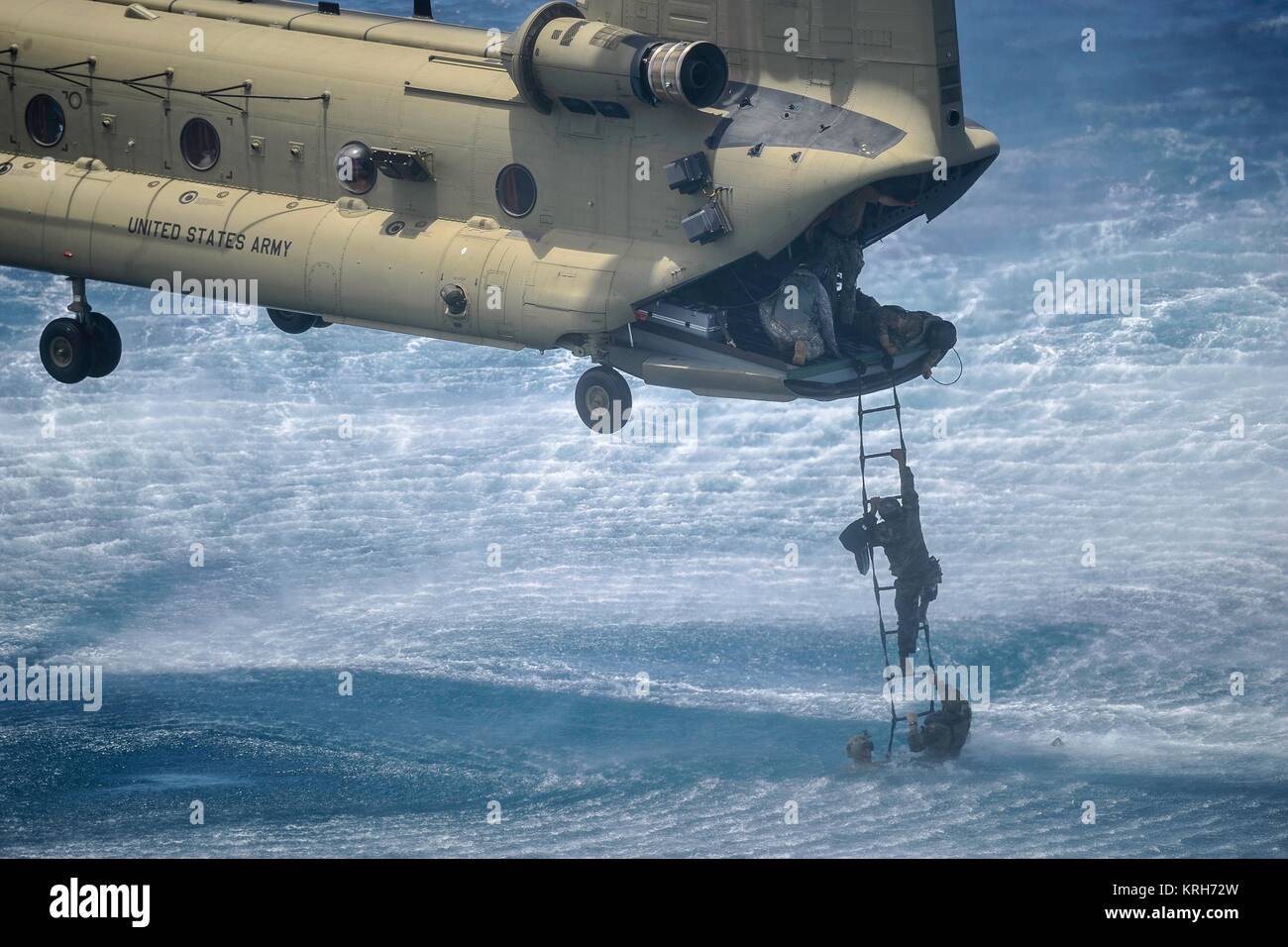 A Belize Coast Guard officer climbs a Jacobs Ladder on to a Boeing CH-47 Chinook helicopter during a training mission July 18, 2016 off the coast of Belize City, Belize. Stock Photo