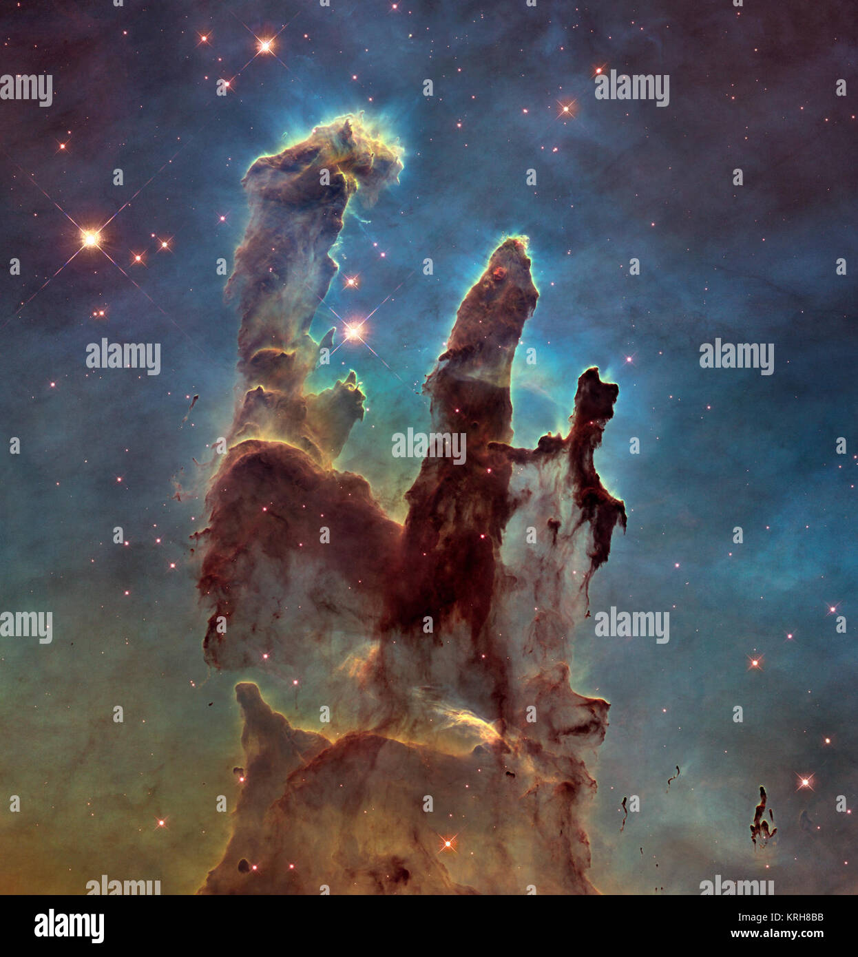 NASA's Hubble Space Telescope has revisited the famous Pillars of Creation, revealing a sharper and wider view of the structures in this visible-light image. Astronomers combined several Hubble exposures to assemble the wider view. The towering pillars are about 5 light-years tall. The dark, finger-like feature at bottom right may be a smaller version of the giant pillars. The new image was taken with Hubble's versatile and sharp-eyed Wide Field Camera 3. The pillars are bathed in the blistering ultraviolet light from a grouping of young, massive stars located off the top of the image. Streame Stock Photo