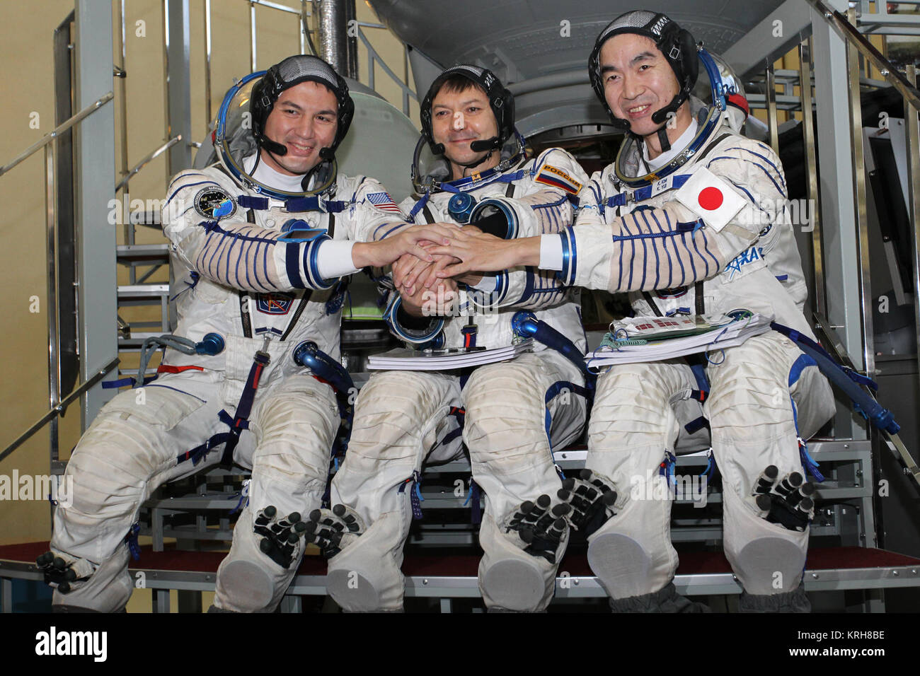 #3263 - (30 October 2014) --- At the Gagarin Cosmonaut Training Center in Star City, Russia, Expedition 42/43 backup crewmembers Kjell Lindgren of NASA (left), Soyuz Commander Oleg Kononenko of the Russian Federal Space Agency (Roscosmos, center) and Kimiya Yui of the Japan Aerospace Exploration Agency (right) pose for pictures in front of a Soyuz simulator October 30 as part of their final qualification exams for flight. They are the backups to the prime crew --- Terry Virts of NASA, Anton Shkaplerov of Roscosmos and Samantha Cristoforetti of the European Space Agency --- who are in the final Stock Photo