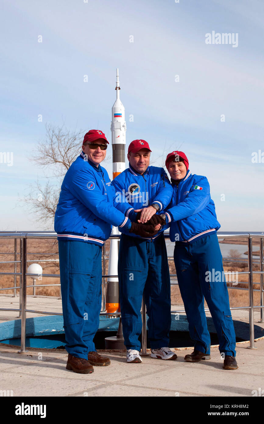6270:  Behind the Cosmonaut Hotel crew quarters in Baikonur, Kazakhstan, Expedition 42/43 crewmembers Terry Virts of NASA (left), Anton Shkaplerov of the Russian Federal Space Agency (Roscosmos, center) and Samantha Cristoforetti of the European Space Agency (right) clasp hands as they pose for pictures Nov. 18 near the end of their pre-flight training. Virts, Cristoforetti and Shkaplerov will launch Nov. 24, Kazakh time, from the Baikonur Cosmodrome in the Soyuz TMA-15M spacecraft for a 5 ½ month mission on the International Space Station.  NASA/Sergei Fyodorov Soyuz TMA-15M crew behind the C Stock Photo