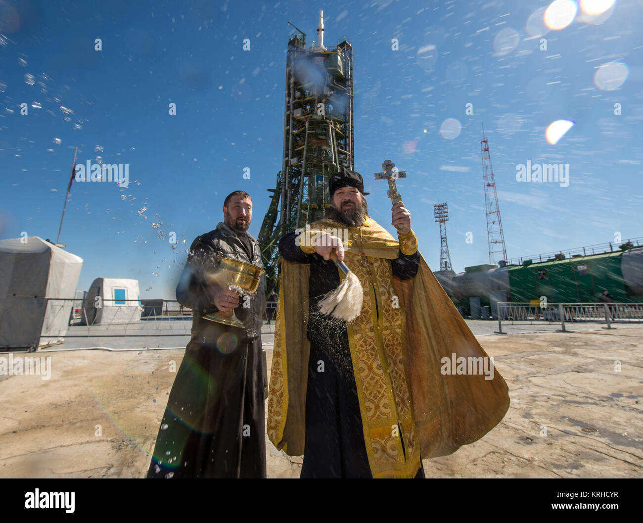 An Orthodox Priest blesses members of the media after he blessed the Soyuz rocket at the Baikonur Cosmodrome Launch pad on Thursday, March 26, 2015 in Kazakhstan. NASA Astronaut Scott Kelly, and Russian Cosmonauts Mikhail Kornienko, and Gennady Padalka of the Russian Federal Space Agency (Roscosmos) are scheduled to launch to the International Space Station in the Soyuz TMA-16M spacecraft from the Baikonur Cosmodrome in Kazakhstan March 28, Kazakh time (March 27 Eastern time.) As the one-year crew, Kelly and Kornienko will return to Earth on Soyuz TMA-18M in March 2016.  Photo Credit (NASA/Bil Stock Photo