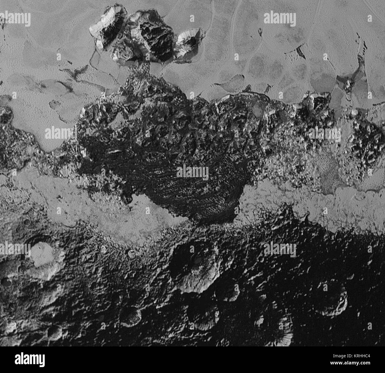 This 220-mile (350-kilometer) wide view of Pluto from NASA’s New Horizons spacecraft illustrates the incredible diversity of surface reflectivities and geological landforms on the dwarf planet. The image includes dark, ancient heavily cratered terrain; bright, smooth geologically young terrain; assembled masses of mountains; and an enigmatic field of dark, aligned ridges that resemble dunes; its origin is under debate. The smallest visible features are 0.5 miles (0.8 kilometers) in size. This image was taken as New Horizons flew past Pluto on July 14, 2015, from a distance of 50,000 miles (80, Stock Photo