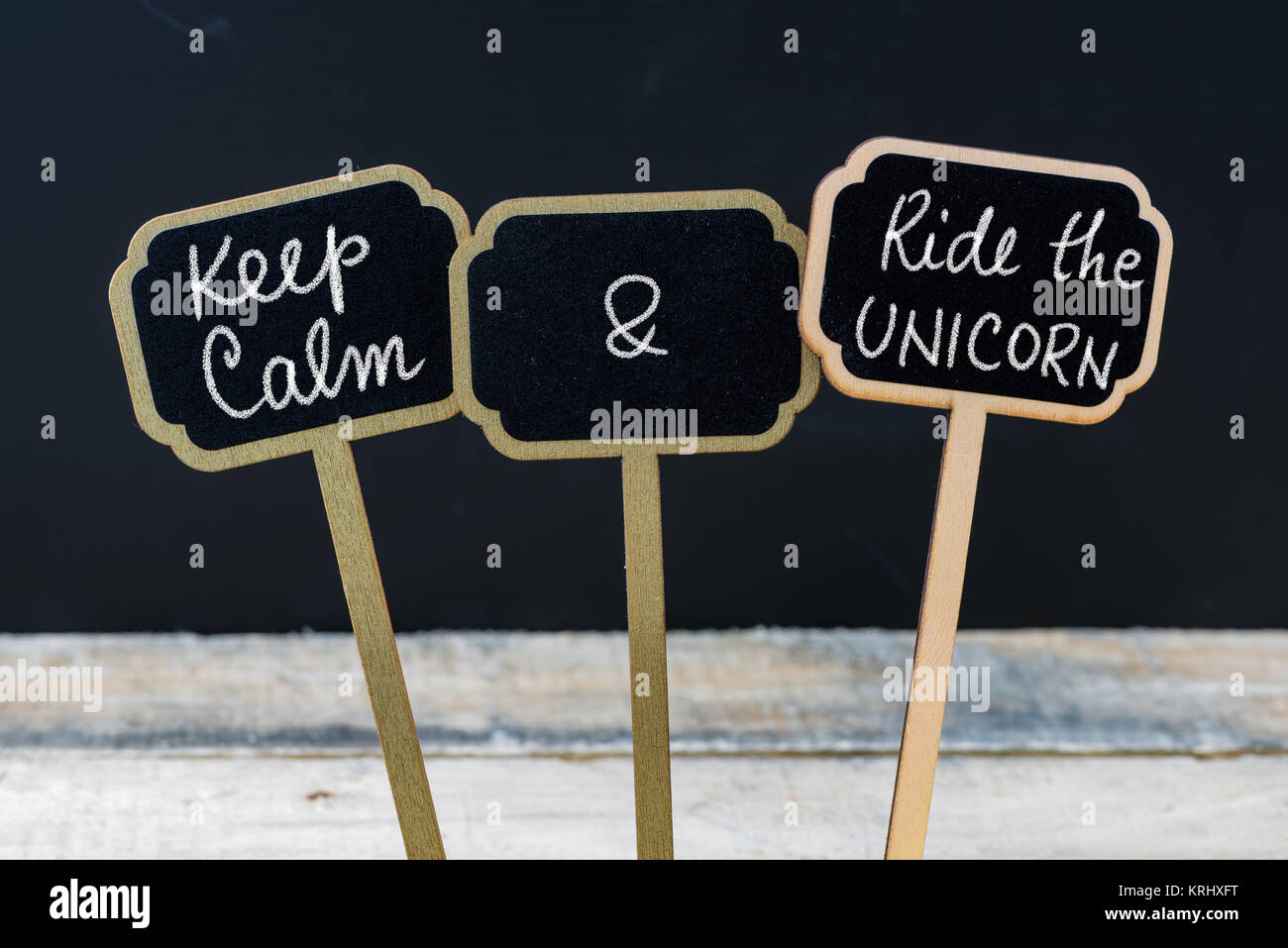 Keep Calm and Ride The Unicorn message written with chalk on mini blackboard labels Stock Photo