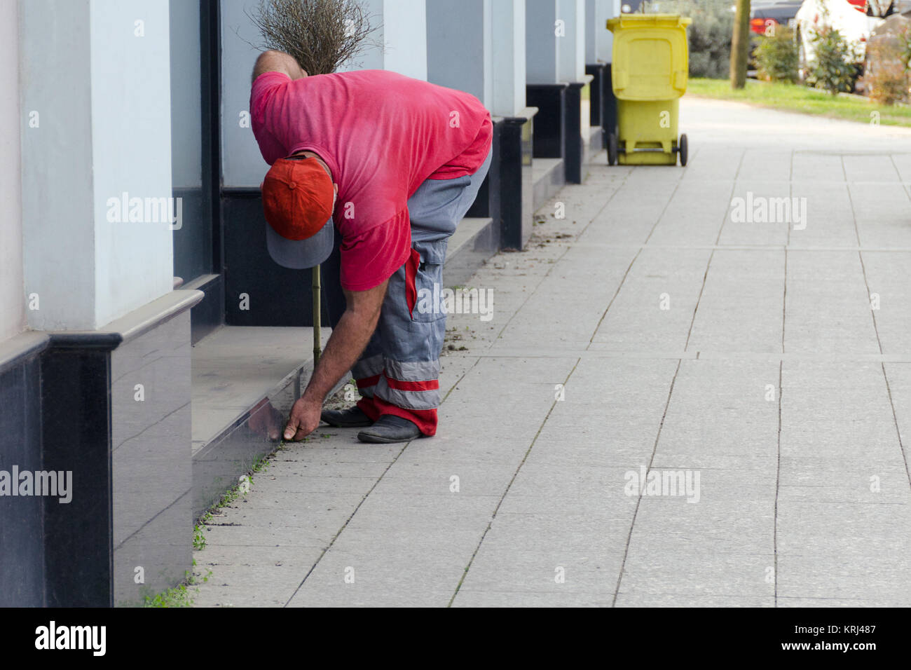 Cleaning of a city street the worker the yard keeper in a uniform