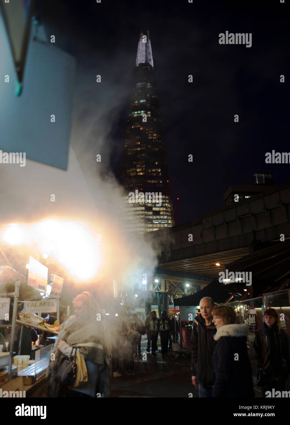 The Shard skyscraper towers above food stalls as evening falls over Borough Market, in London, Britain December 19, 2017 Stock Photo