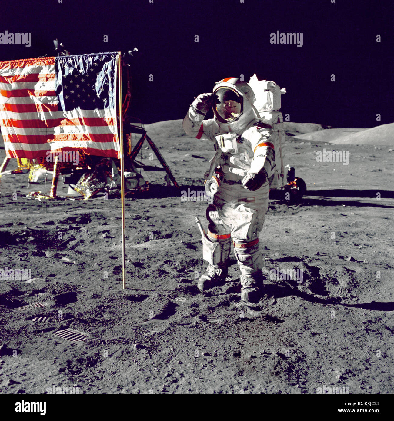 Eugene A. Cernan, Commander, Apollo 17 salutes the flag on the lunar surface during extravehicular activity (EVA) on NASA's final lunar landing mission. The Lunar Module 'Challenger' is in the left background behind the flag and the Lunar Roving Vehicle (LRV) also in background behind him. While astronauts Cernan and Schmitt descended in the Challenger to explore the Taurus-Littrow region of the Moon, astronaut Ronald E. Evans, Command Module pilot, remained with the Command/Service Module (CSM) 'America' in lunar-orbit. Cernan Jump Salutes Flag (9460247018) Stock Photo