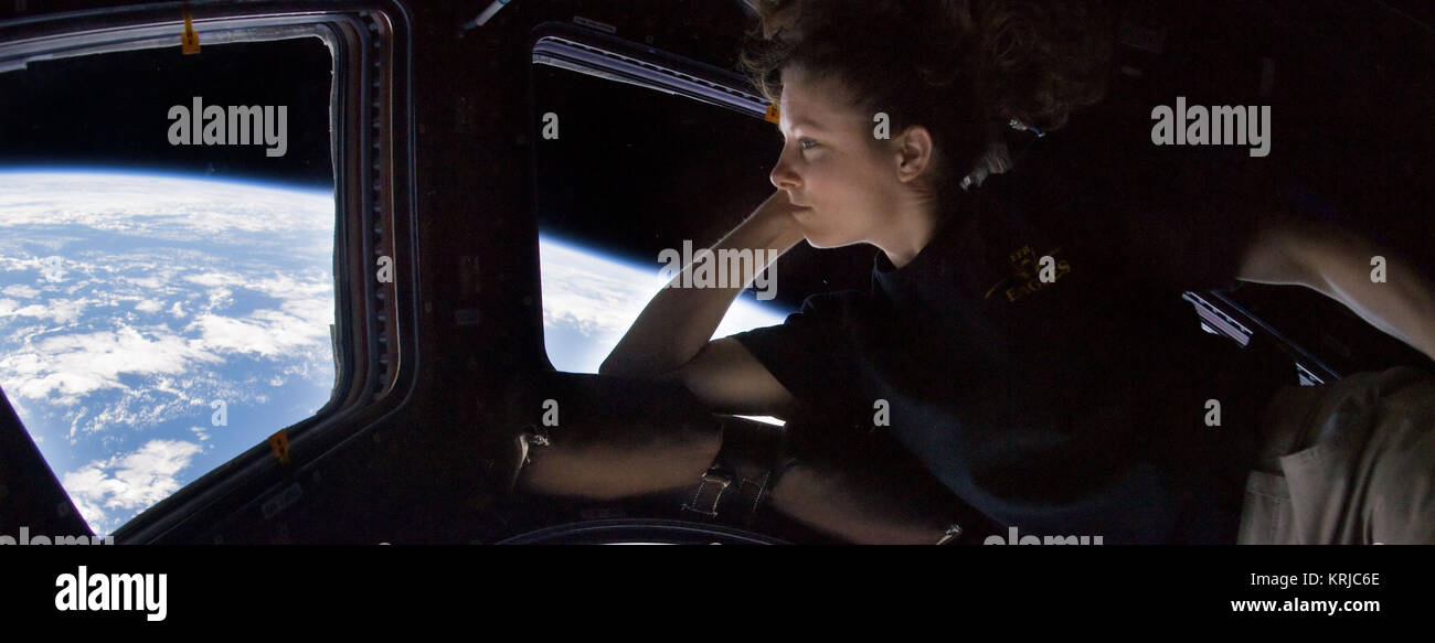 ISS024-E-014263 (11 Sept. 2010) --- NASA astronaut Tracy Caldwell Dyson, Expedition 24 flight engineer, looks through a window in the Cupola of the International Space Station. A blue and white part of Earth and the blackness of space are visible through the windows. Tracy Caldwell Dyson in Cupola ISS Wide Stock Photo