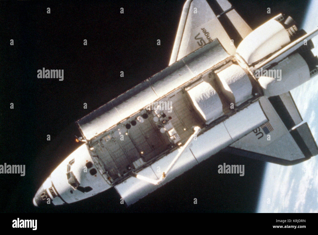 An overhead view of the space shuttle Challenger taken by a fixed camera mounted on astronaut Bruce McCandless's helmet during the first extravehicular activity (EVA) using the nitrogen-propelled, hand-controlled, manned maneuvering unit (MMU).  The MMU is a device which allows astronauts to move freely in space without a tether. View from Manned Maneuvering Unit Stock Photo