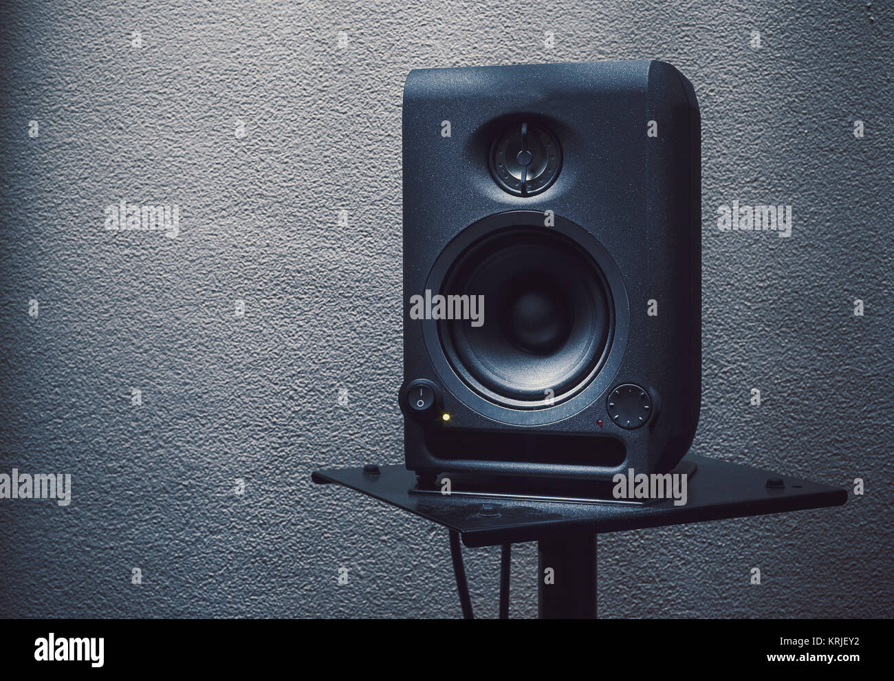 Modern studio monitor on stand, speaker details. Stock Photo