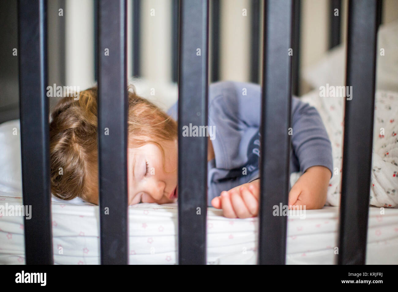Caucasian baby girl sleeping in crib Stock Photo