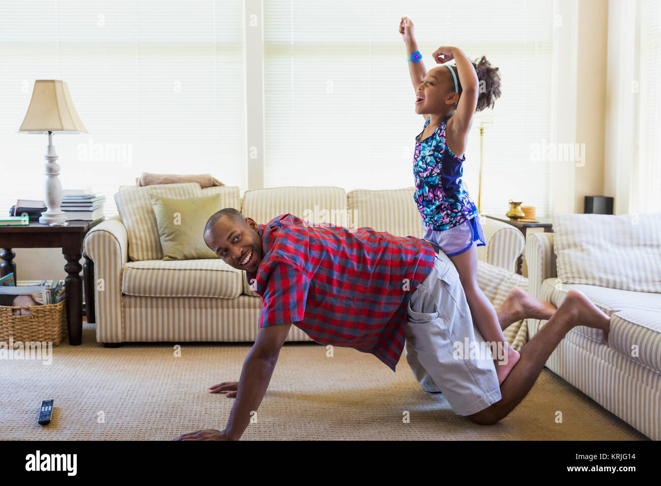 Mixed race father and daughter playing on floor in livingroom Stock Photo