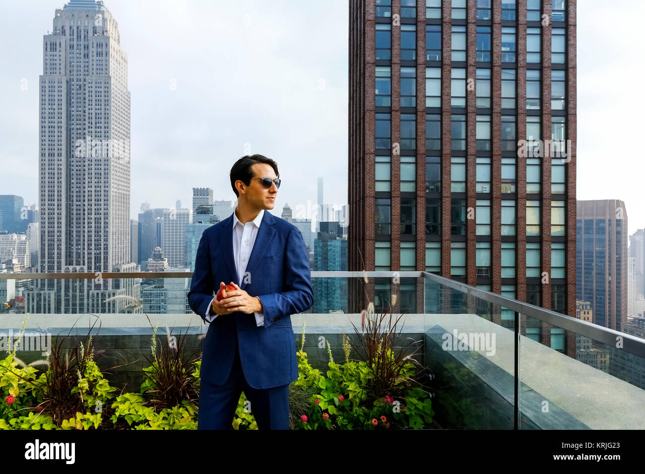 Caucasian businessman holding apple on urban rooftop Stock Photo