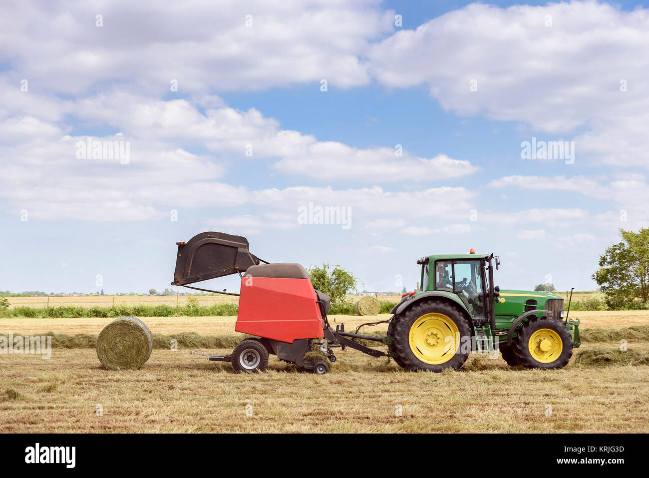 Caucasian man driving tractor baling hay Stock Photo Alamy