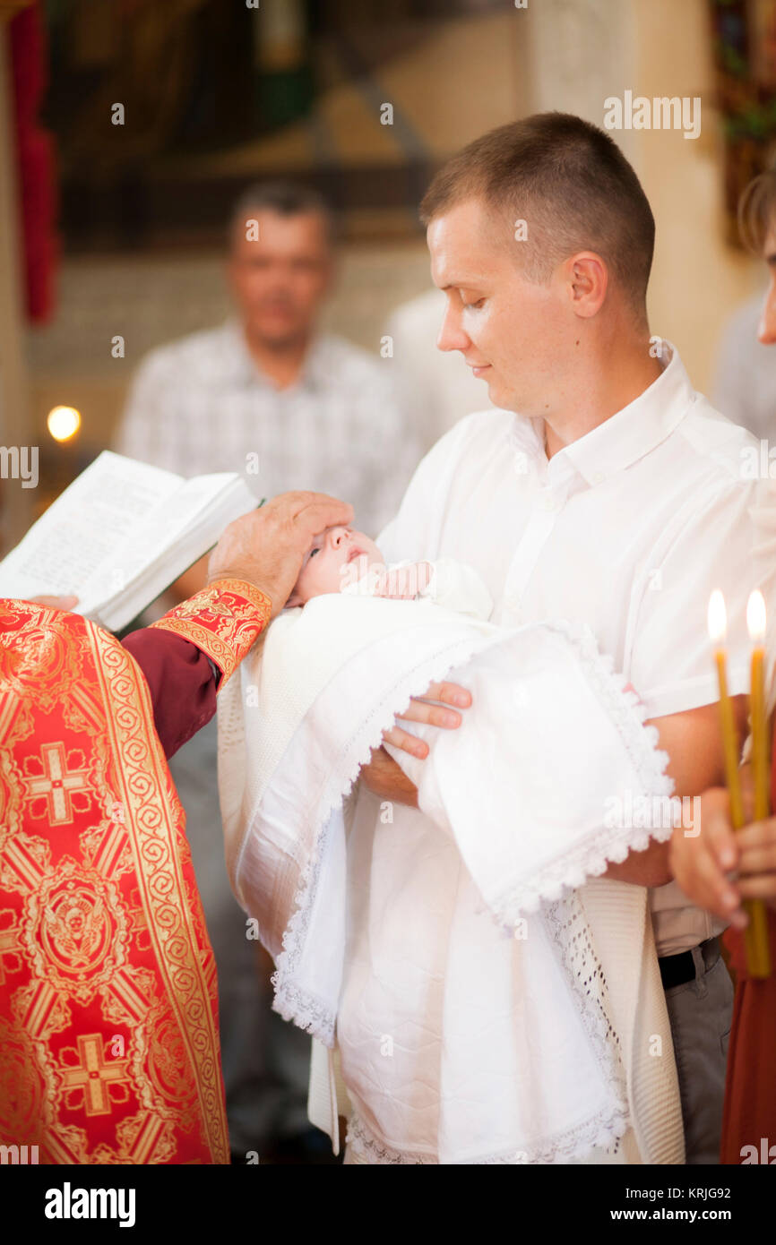 Priest blessing baby boy in church Stock Photo