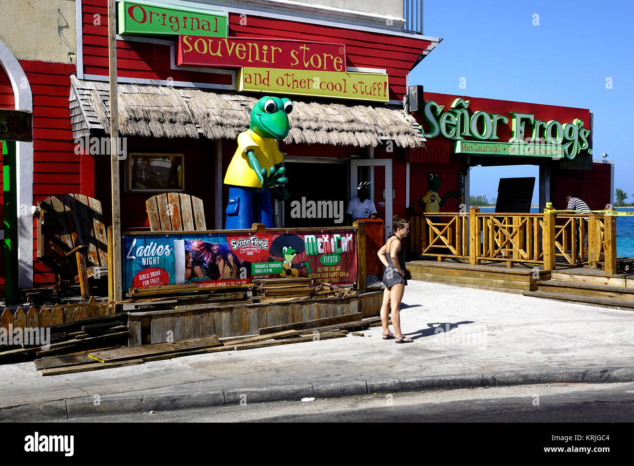 A woman stands in front of Senior Frogs in Nassau, Bahamas. Stock Photo
