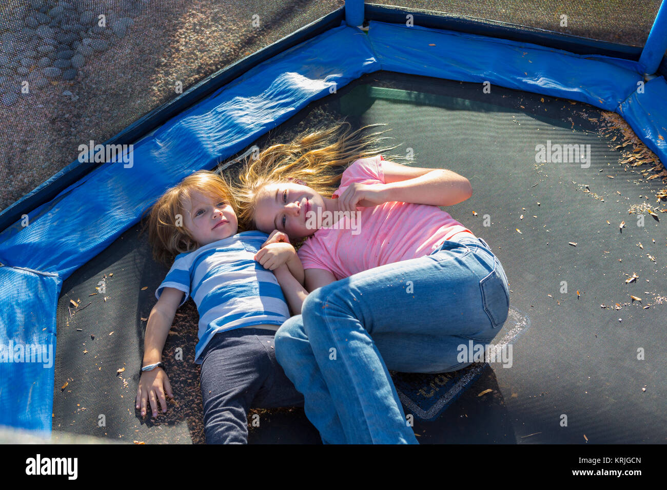 Caucasian brother and sister laying on trampoline Stock Photo