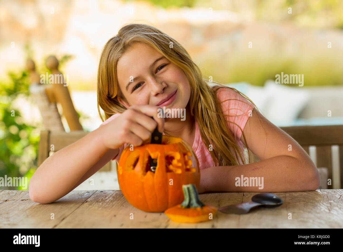 Portrait of smiling Caucasian girl with carved pumpkin Stock Photo