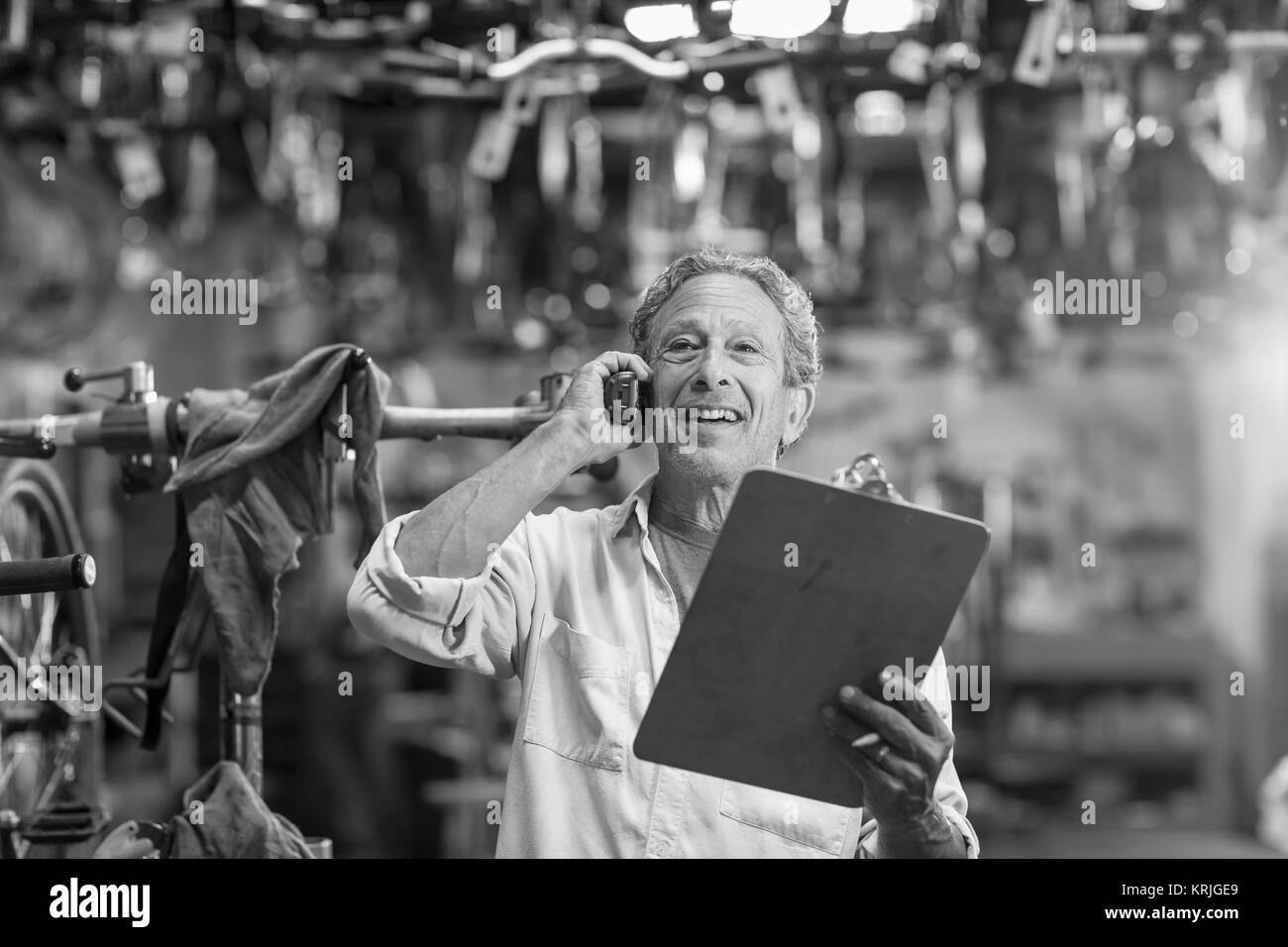 Caucasian man in bicycle shop talking on telephone Stock Photo