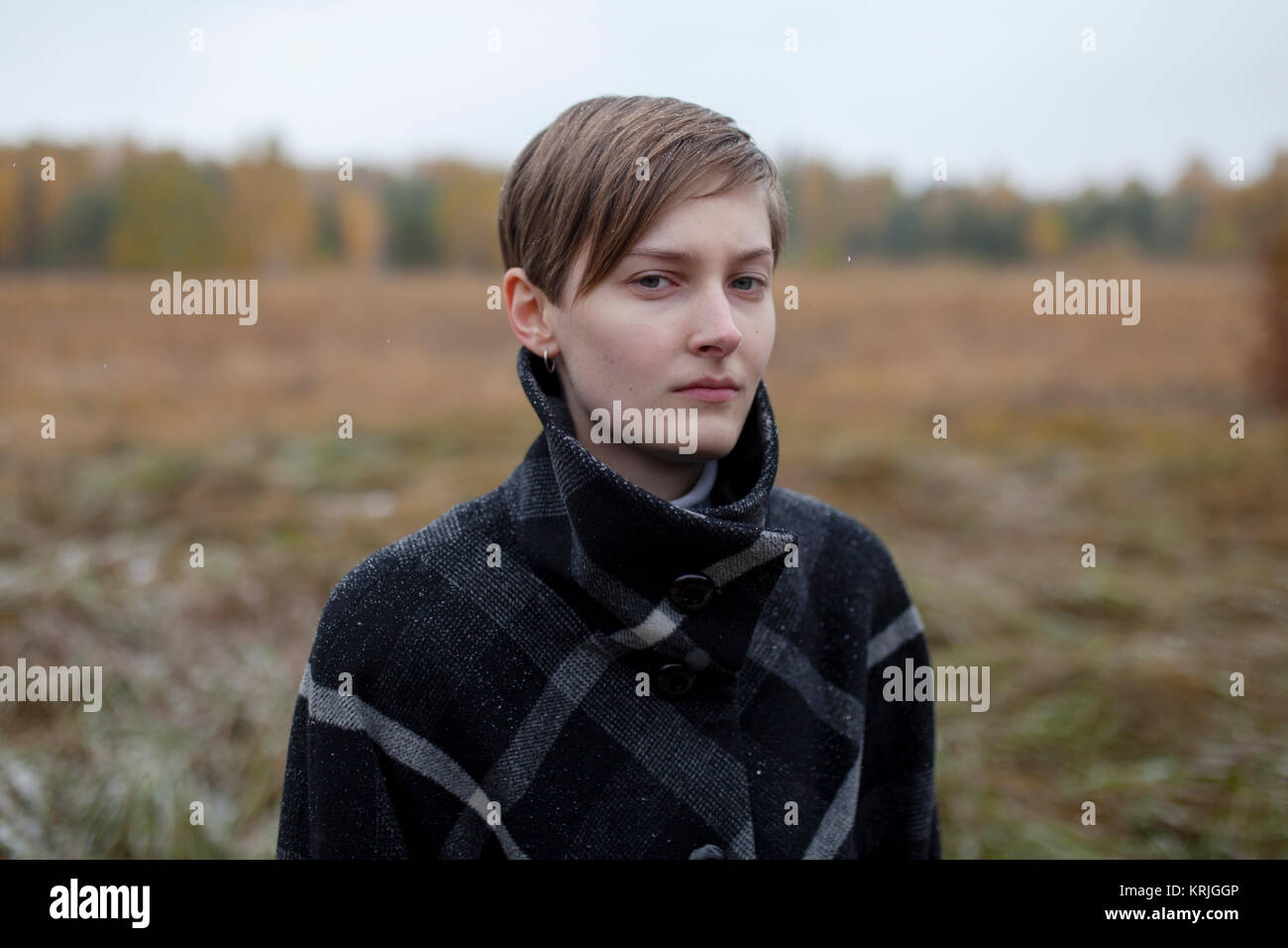 Portrait of serious Caucasian woman standing in field Stock Photo