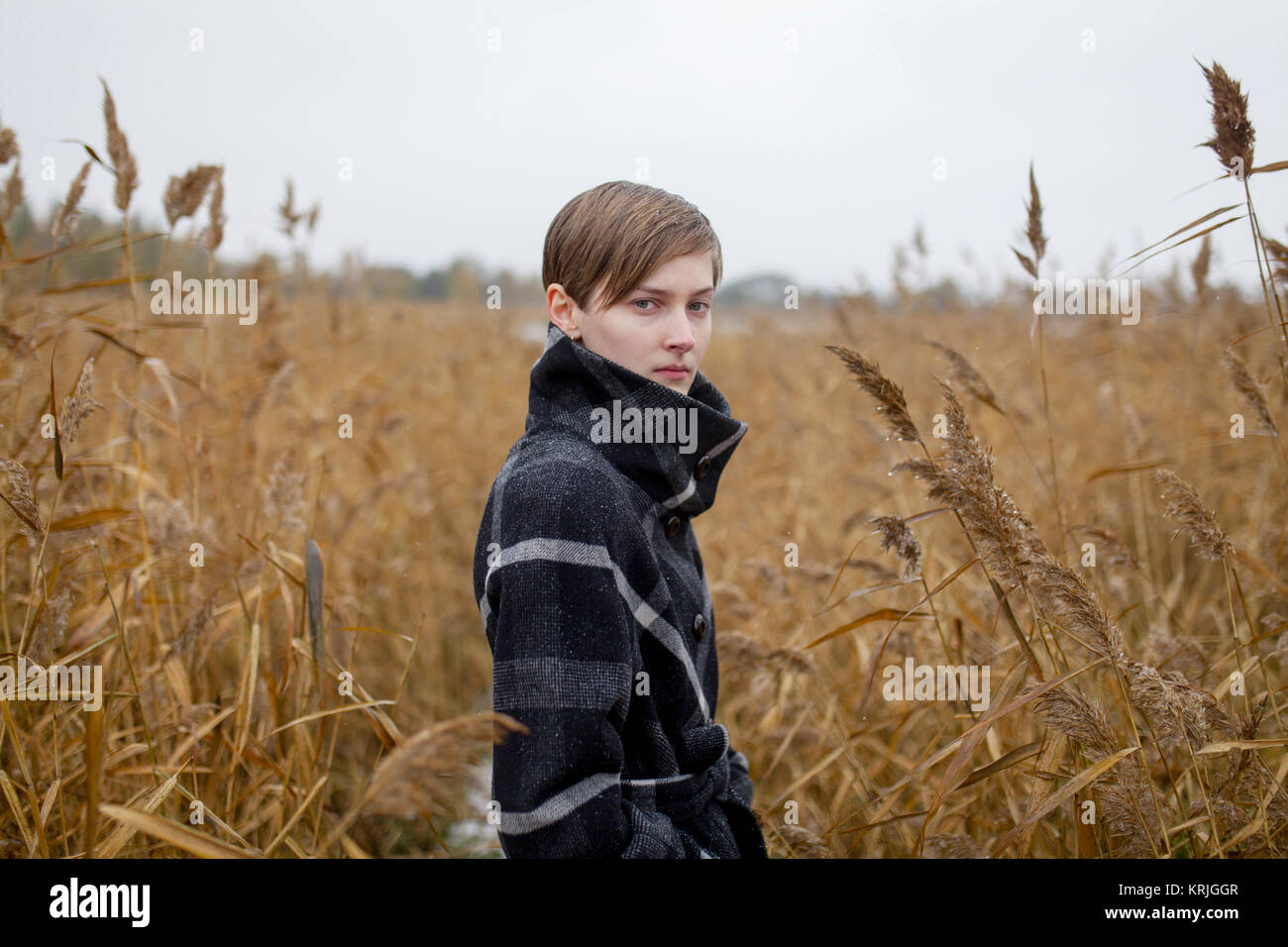 Portrait of serious Caucasian woman standing in field Stock Photo