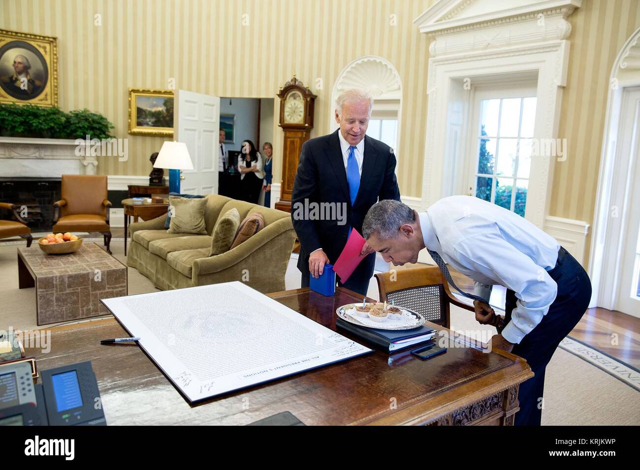 U.S. Vice President Joe Biden looks on as U.S. President Barack Obama blows out birthday candles White House Oval Office August 4, 2016 in Washington, DC. Stock Photo