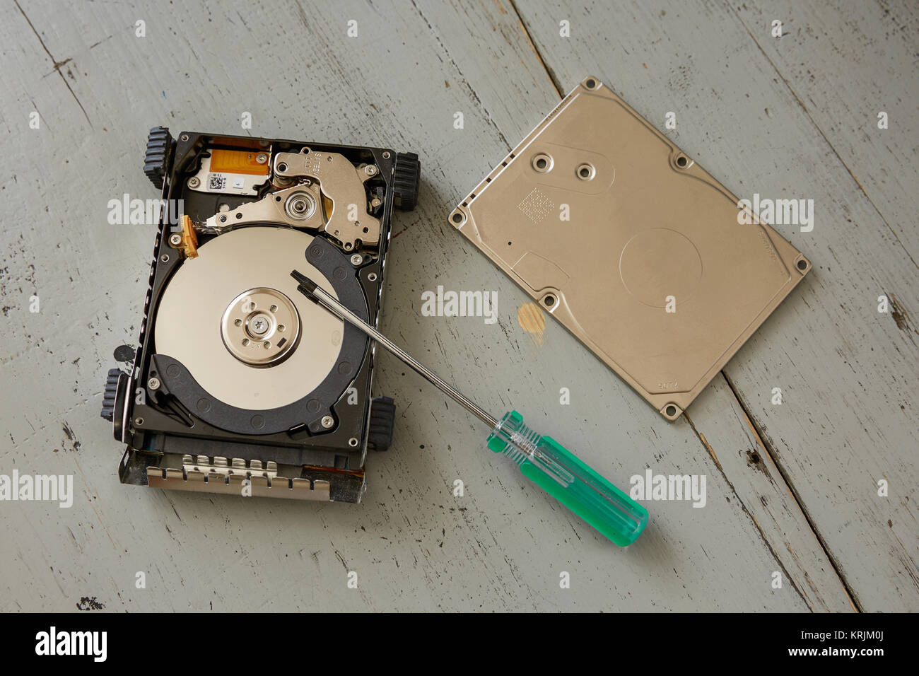 Broken and Destroyed Hard Drive Disk and Tools on Wooden Table Stock