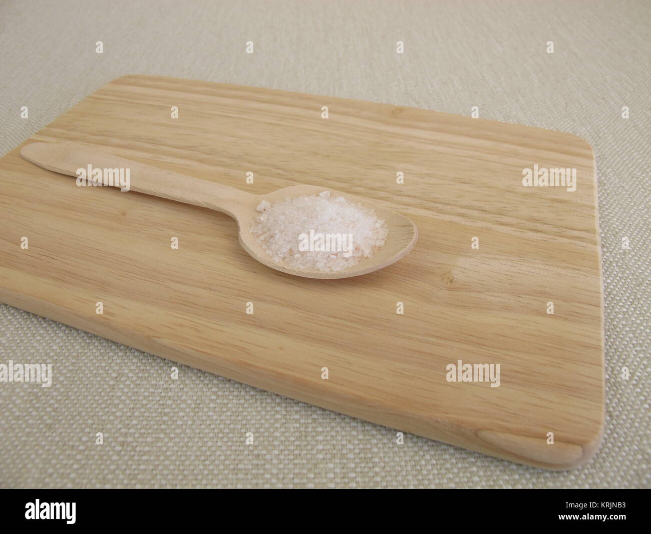 six grams of salt per day on a wooden spoon Stock Photo Alamy