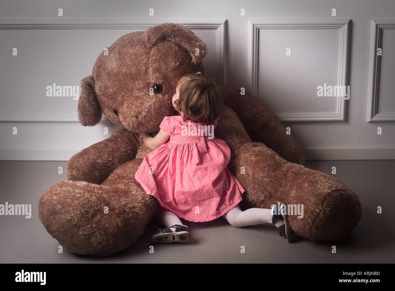 girl hugging huge teddy bear