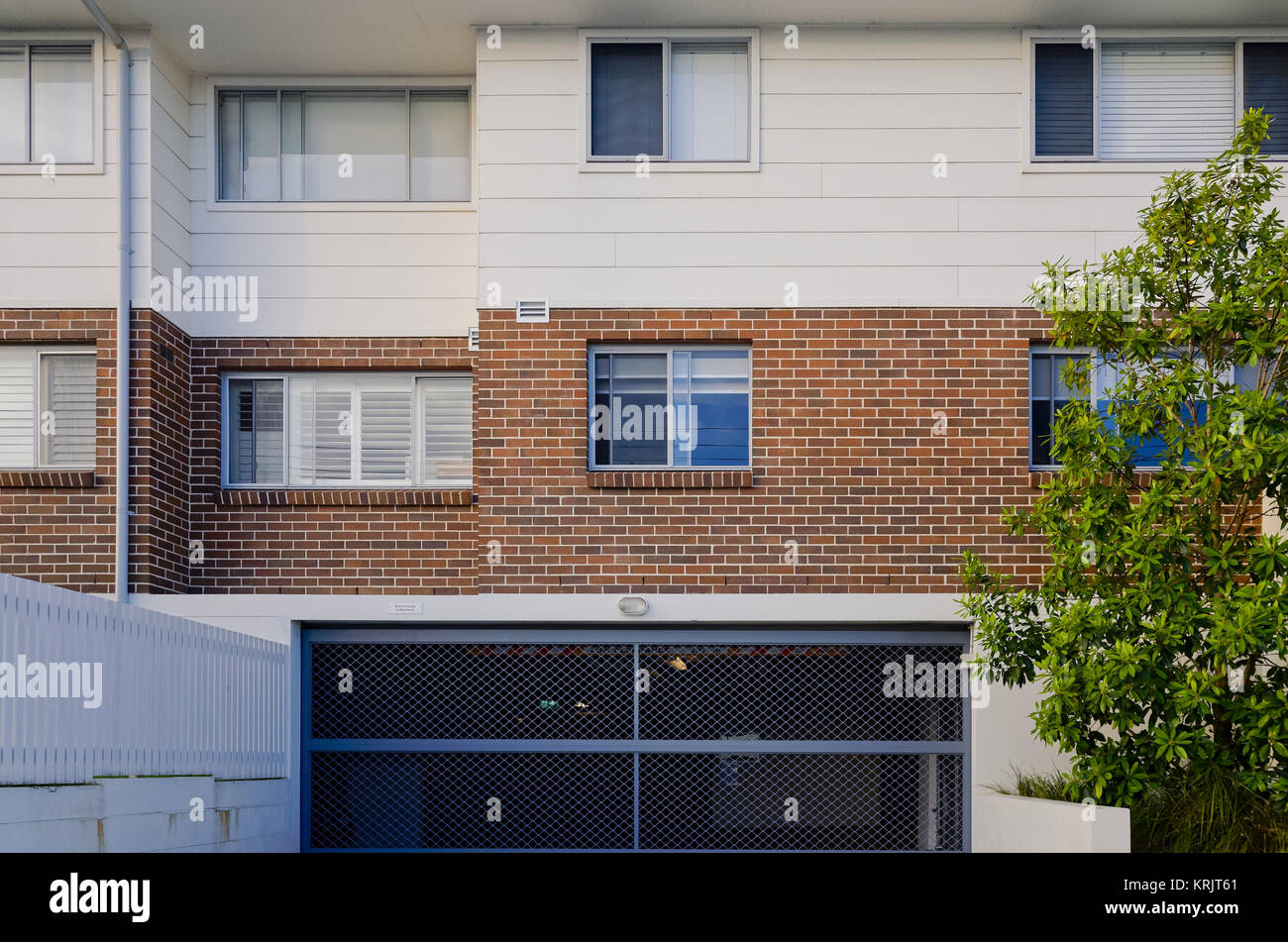 Modern residential apartment building exterior with windows and garage