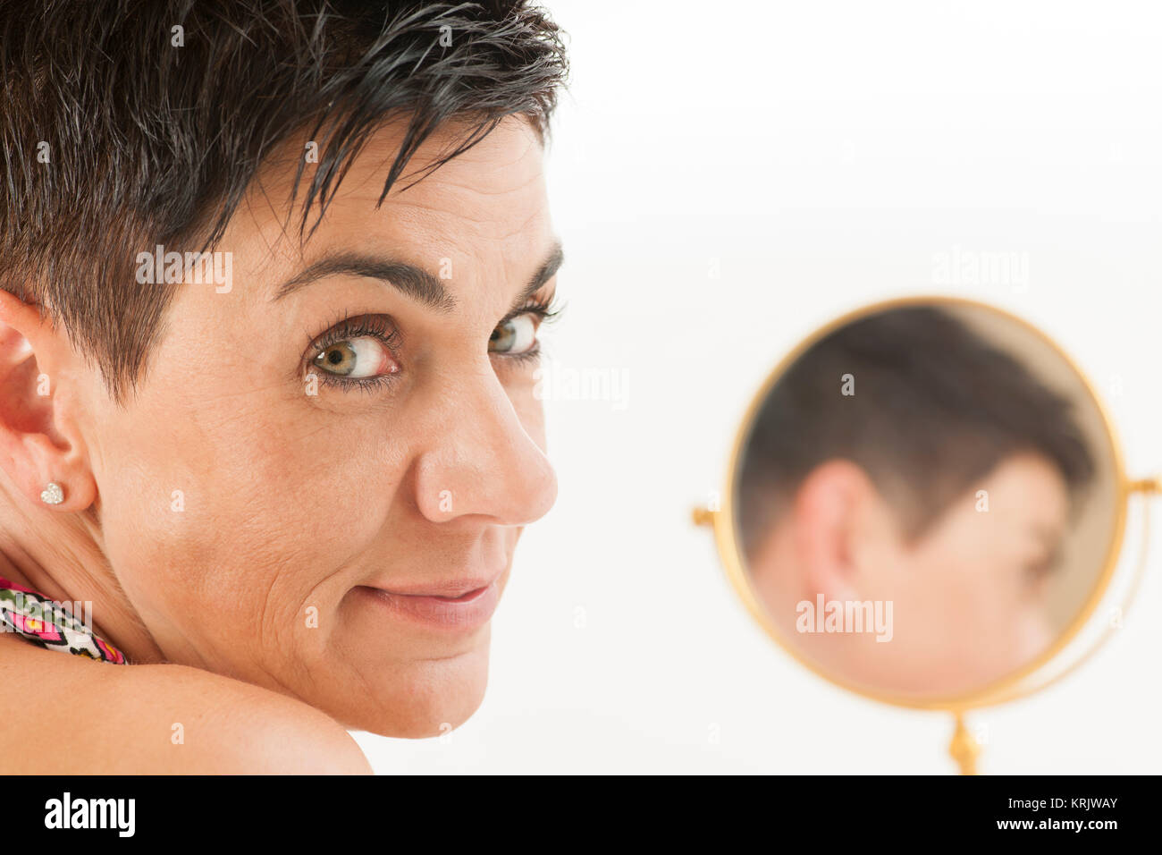 face of woman looks into the camera with mirror Stock Photo