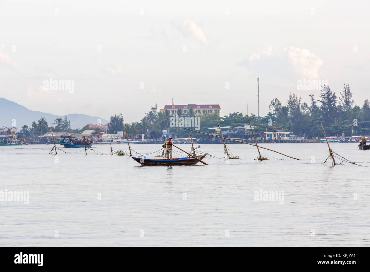 Large fishing net in the water, with local fishermen in little manmade  boats, Vietnam Stock Photo - Alamy