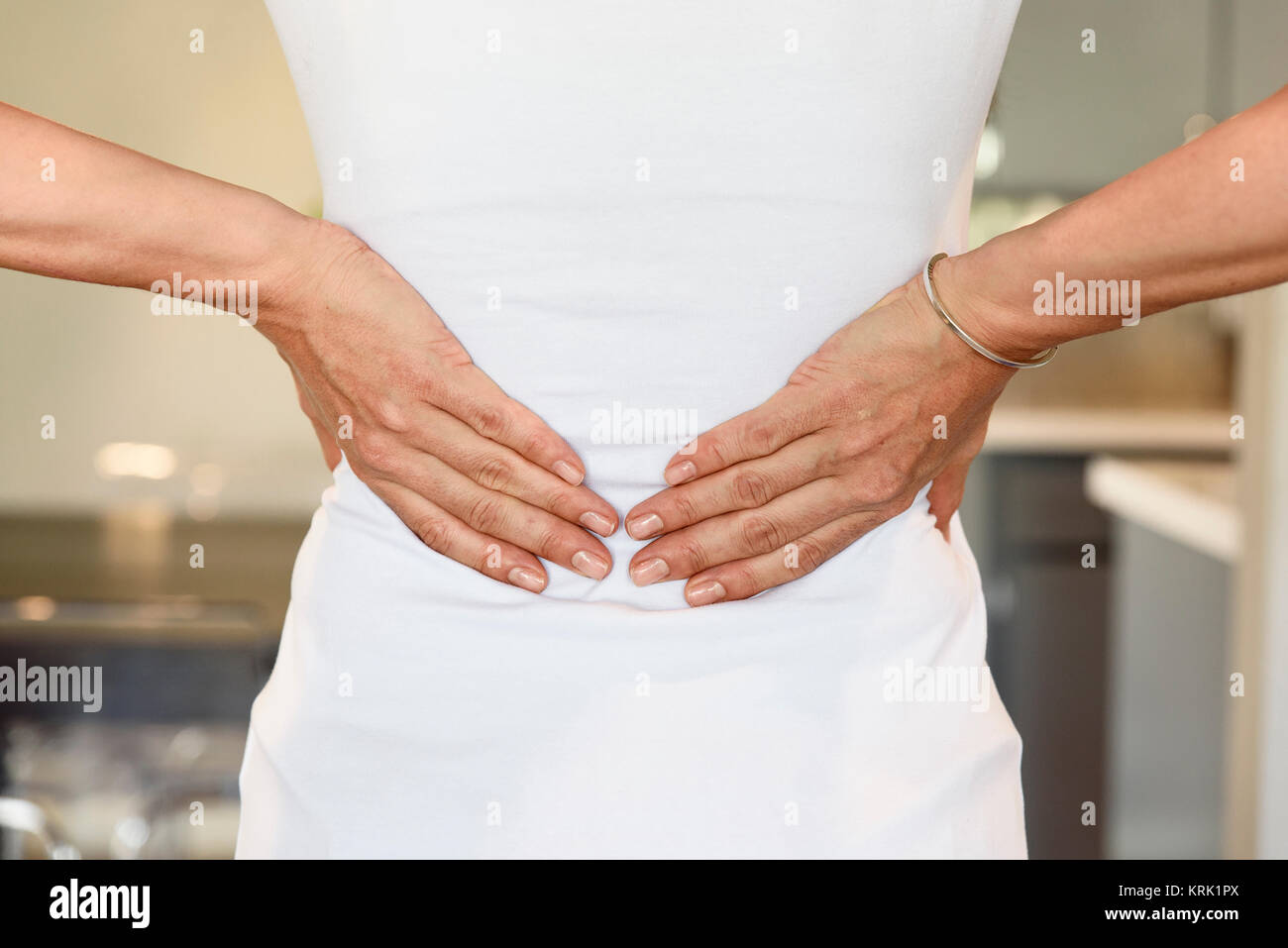 Hands of mixed race woman rubbing lower back Stock Photo