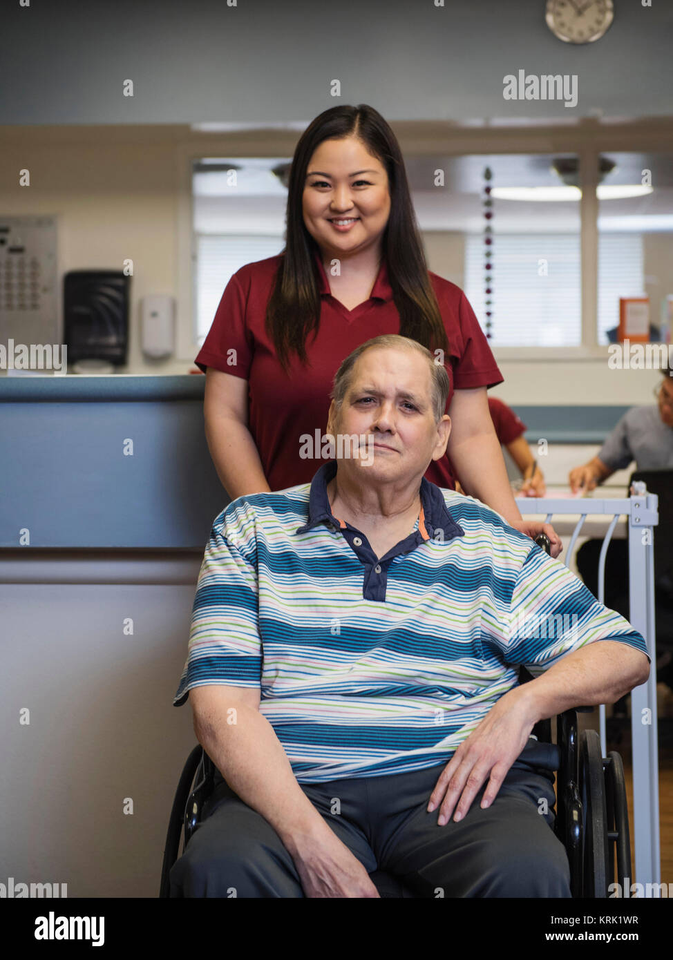 Portrait of smiling nurse and patient in wheelchair Stock Photo