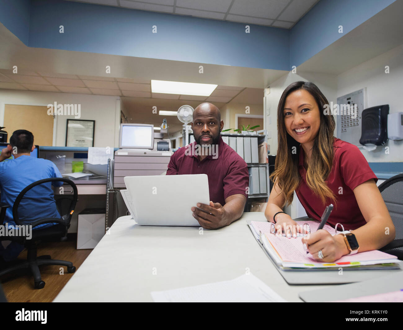 Portrait of smiling nurses with binders and hospital Stock Photo