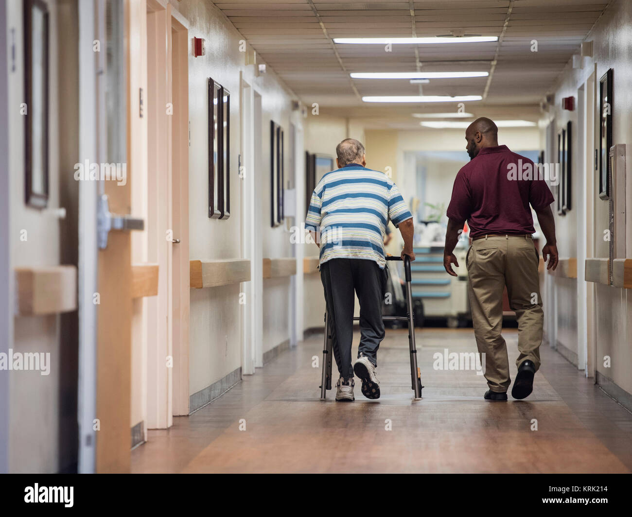 Nurse walking with patient using walker Stock Photo
