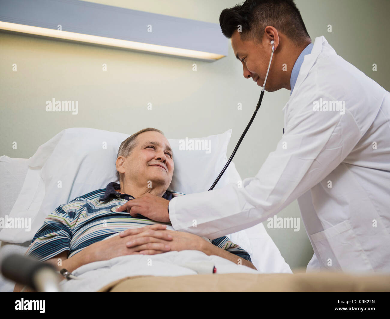Doctor listening to chest of patient with stethoscope Stock Photo