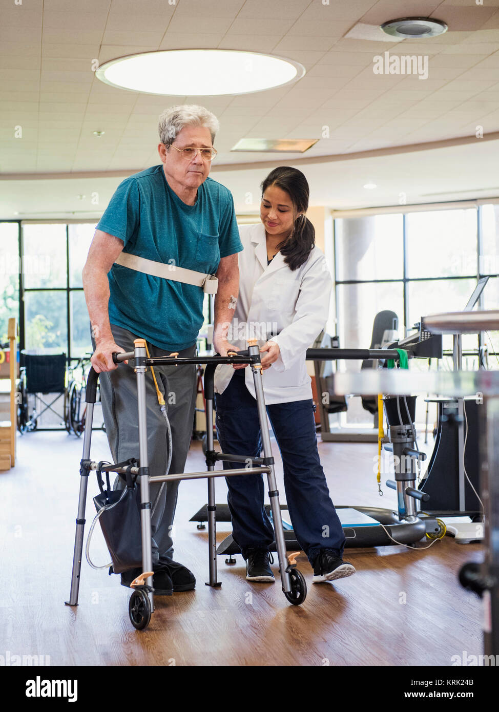 Physical therapist helping man using walker Stock Photo Alamy