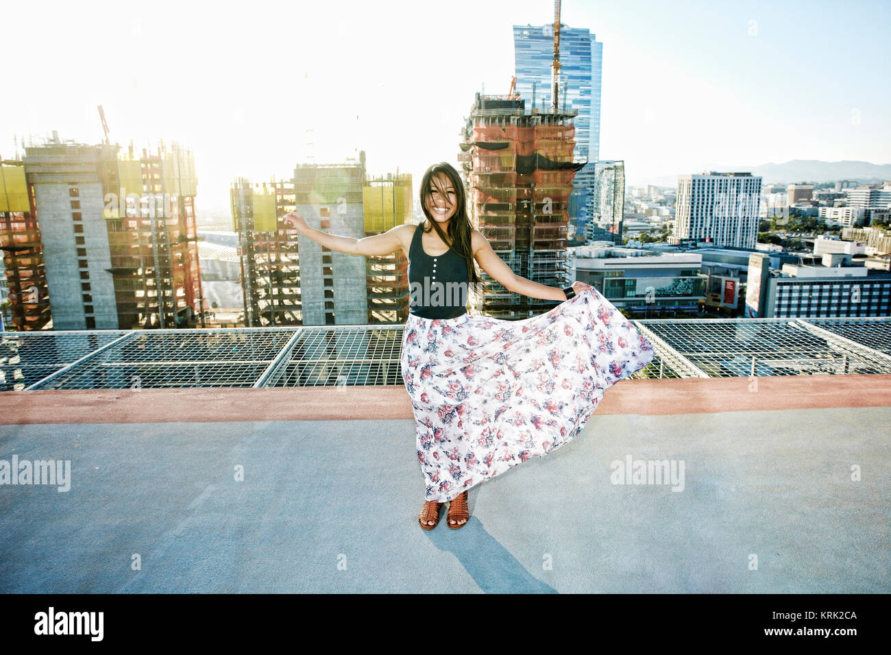 Asian woman dancing on urban rooftop Stock Photo