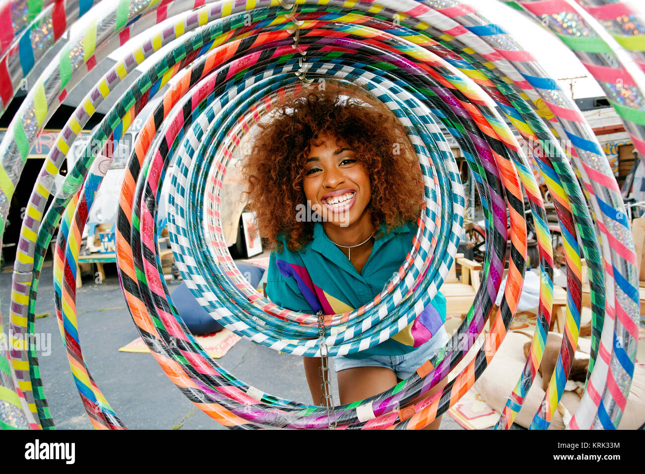 Portrait of smiling black woman behind hoops Stock Photo