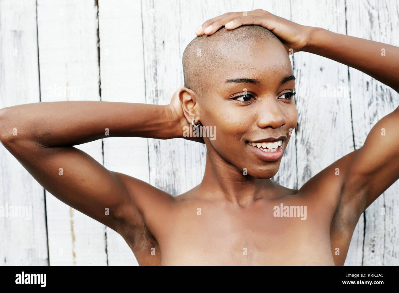 Close up of naked black woman rubbing bald head Stock Photo