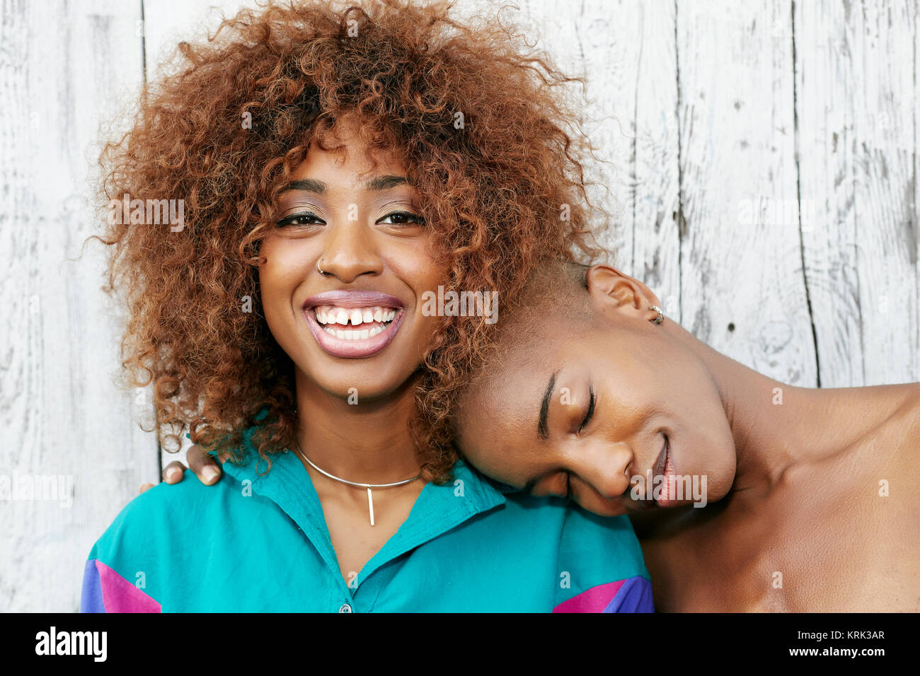 Bald black woman leaning head on shoulder of friend Stock Photo