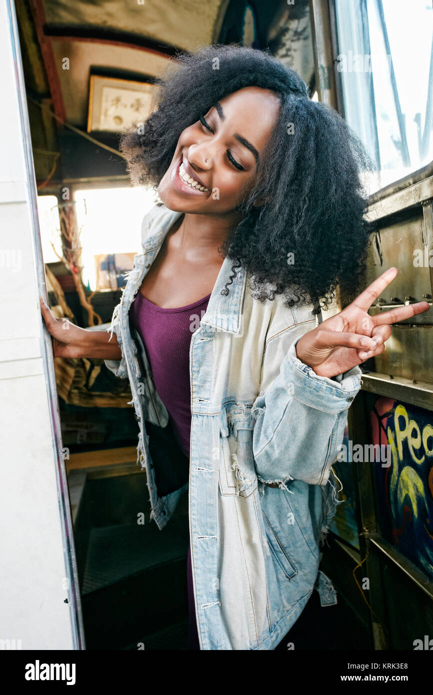 Mixed race woman gesturing peace sign on bus Stock Photo