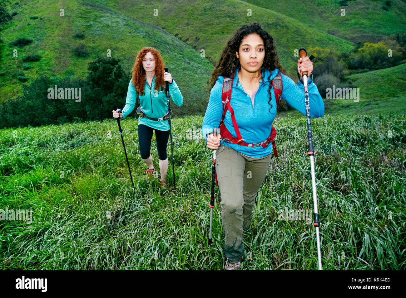 Serious women hiking with walking sticks Stock Photo