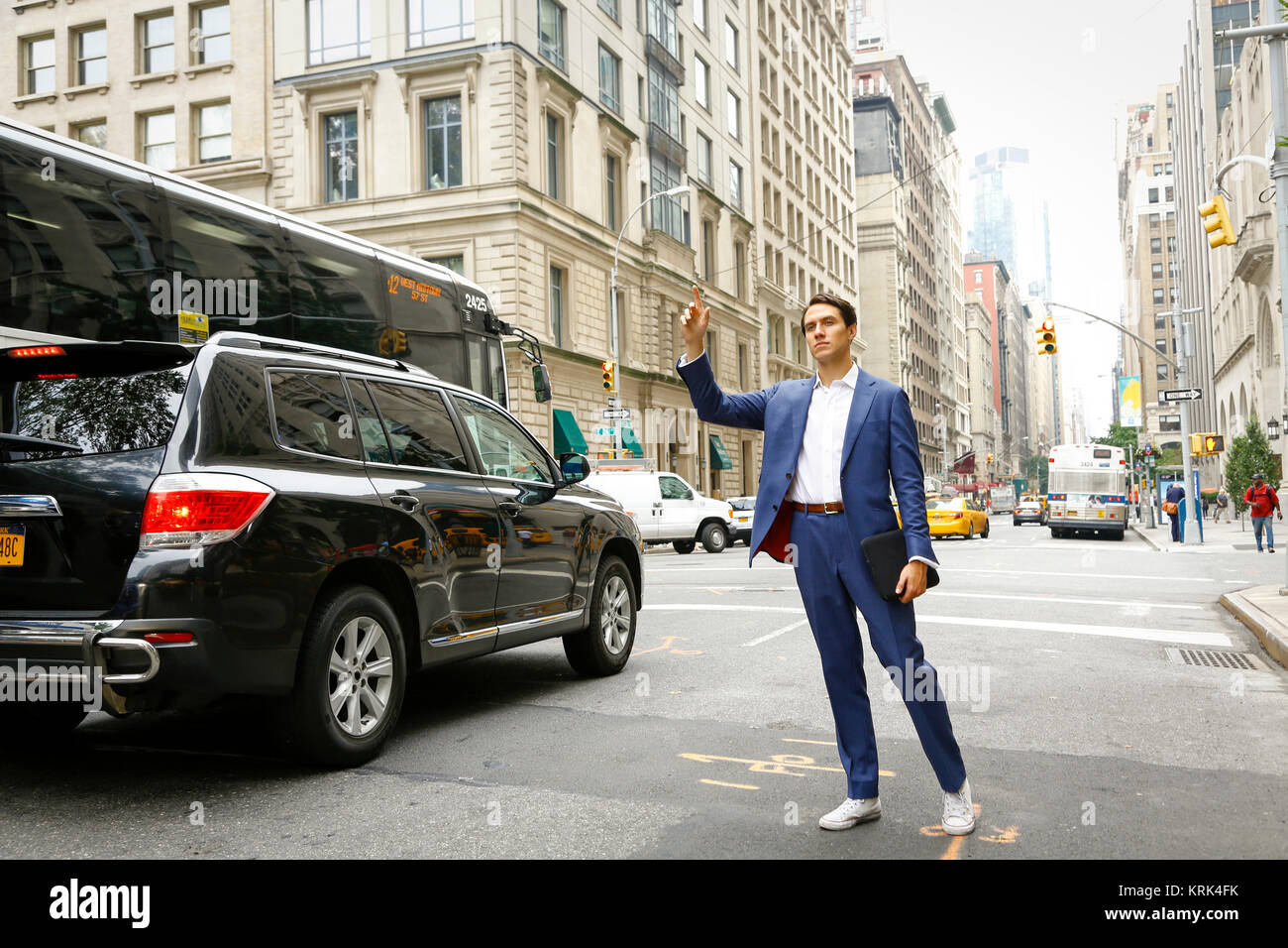 Caucasian businessman standing in street hailing taxi Stock Photo