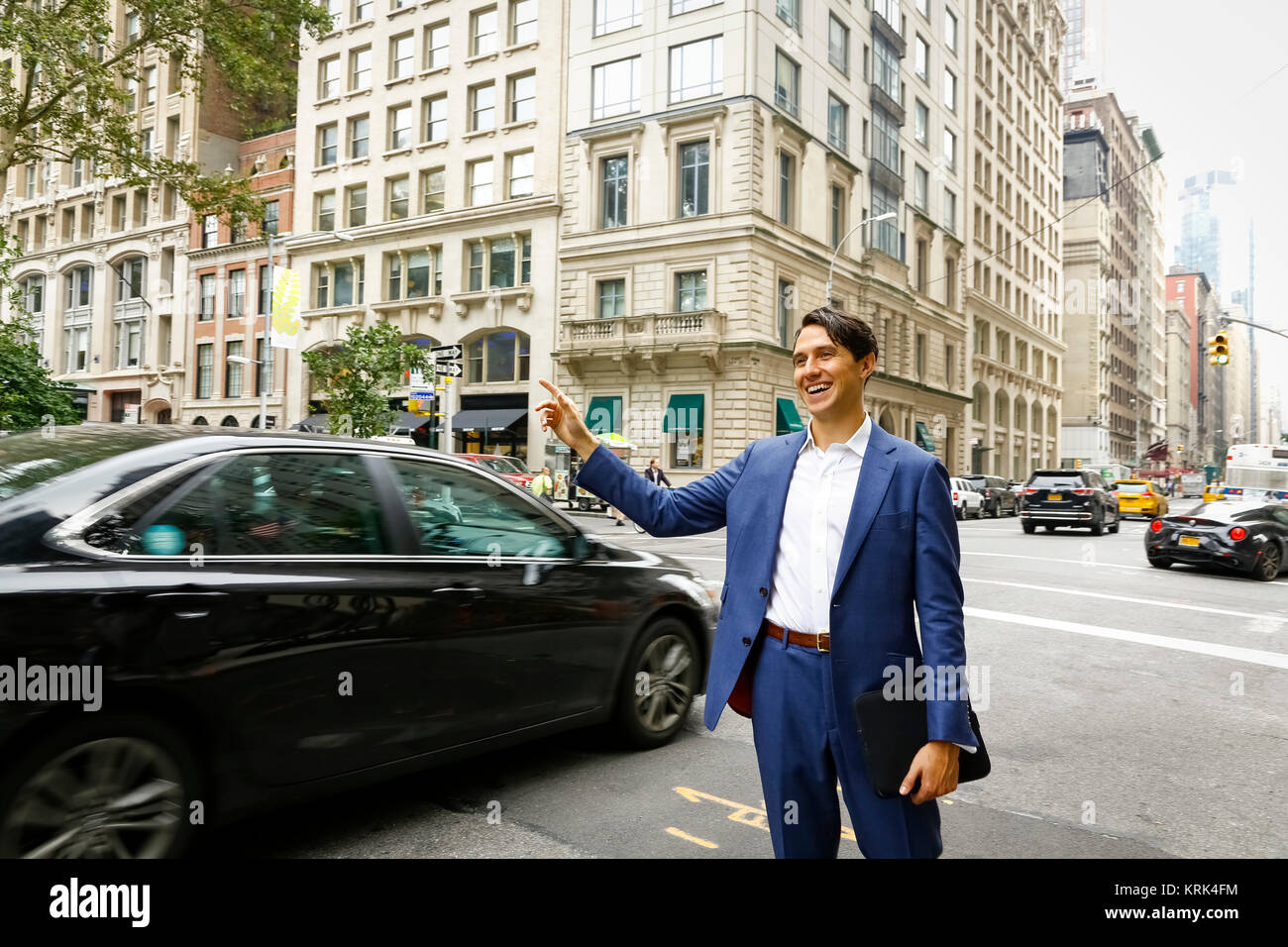 Caucasian businessman standing in street hailing taxi Stock Photo