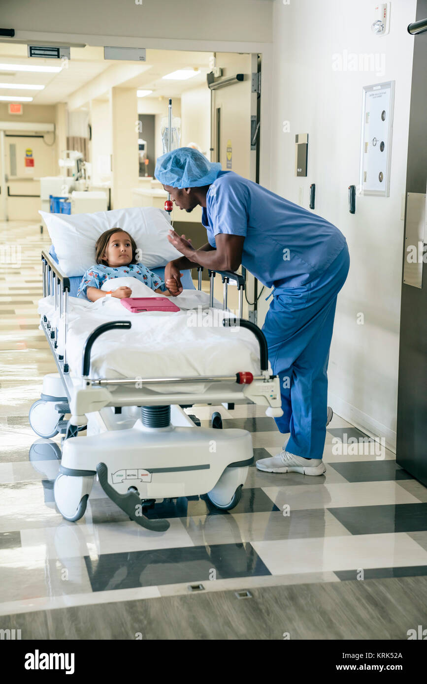 Nurse talking to girl in hospital gurney Stock Photo