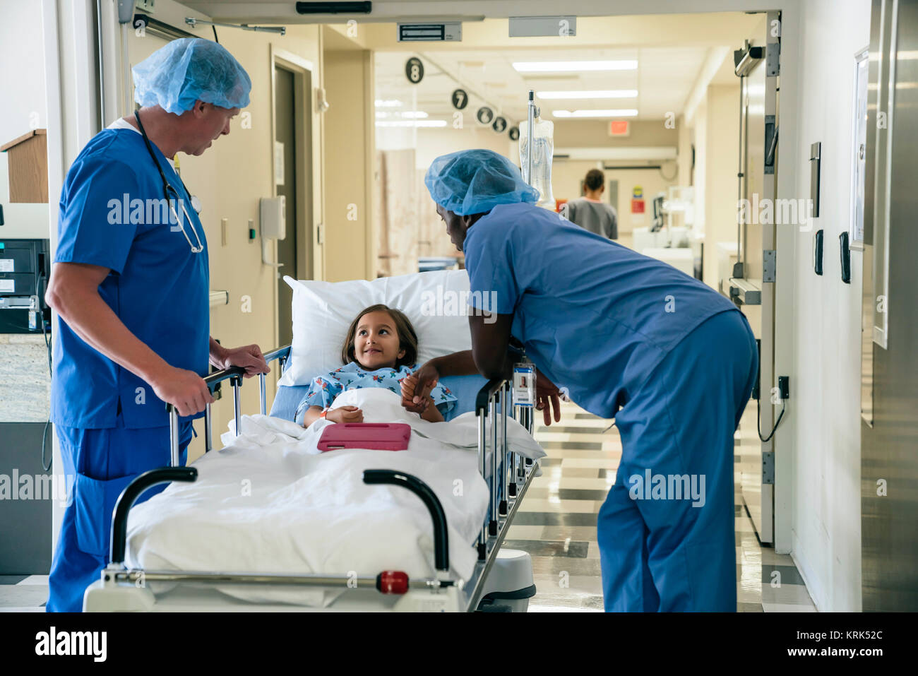 Nurses talking to girl in hospital gurney Stock Photo
